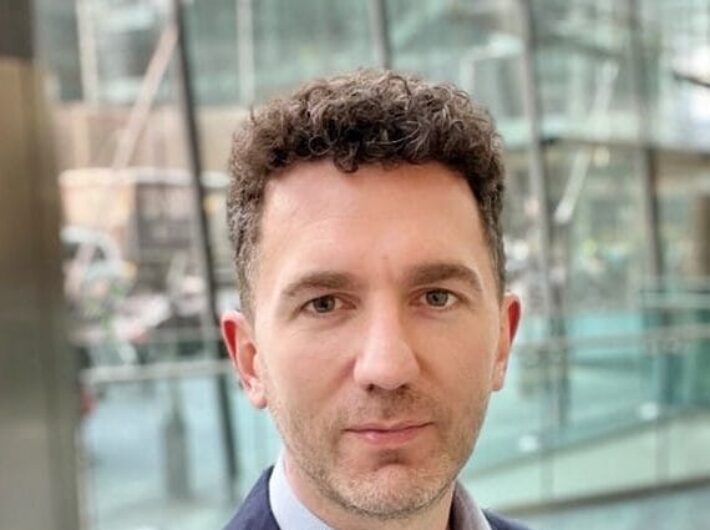 A man with short dark hair looking at the camera