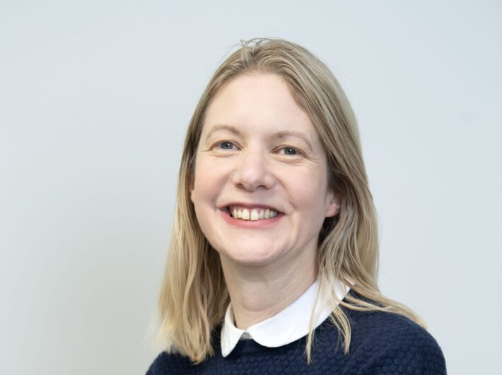 A women with blonde hair smiling at the camera