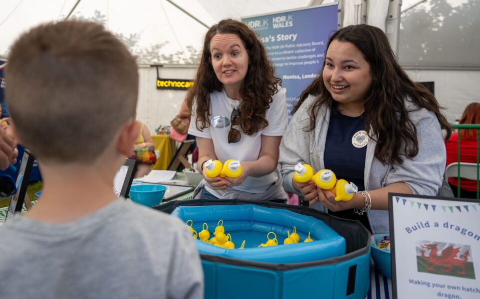 Two people talking to a child at a HDR UK stall