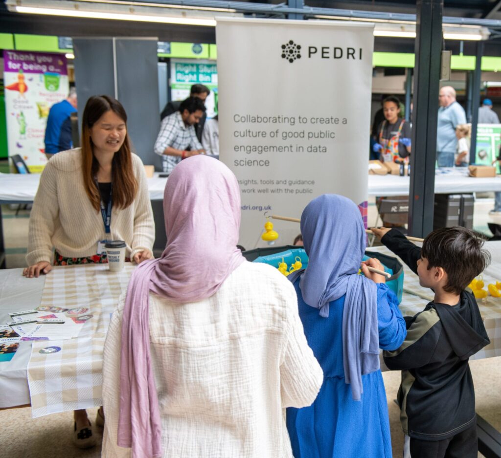 A group of young people play speak across a table with an adult.