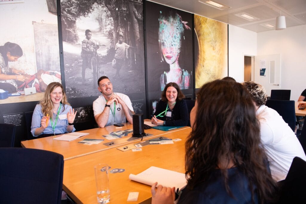 A group of people sit around a table smiling