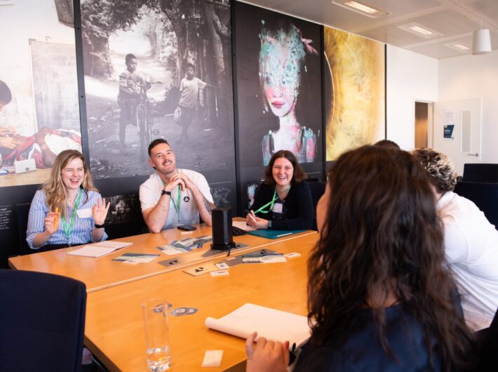 A group of people sit around a table smiling