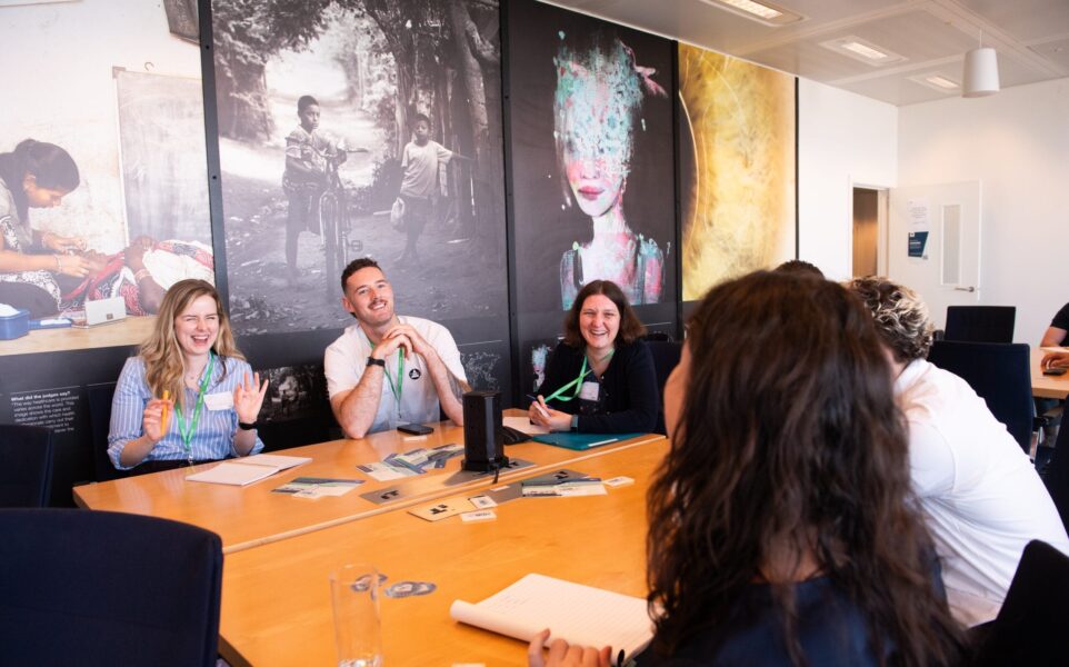 A group of people sit around a table smiling
