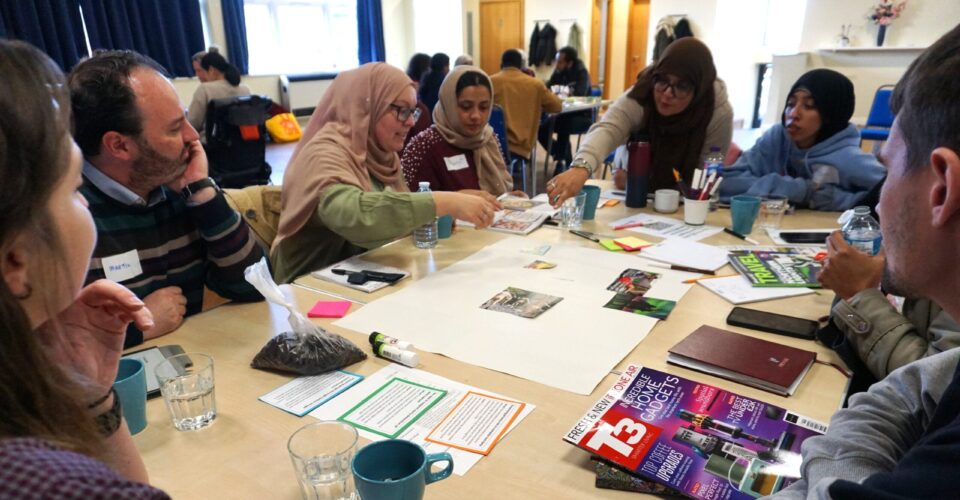 People sat around table sticking images to flipchart paper