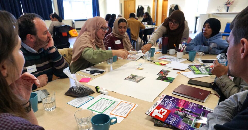 People sat around table sticking images to flipchart paper