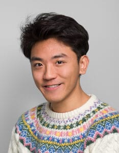 Man with dark hair smiling at the camera