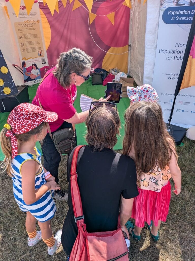 Woman showing her tablet to another person and three children